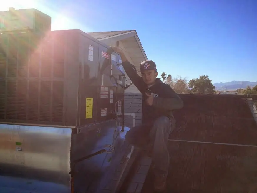 HVAC technician performing AC Tune-Up on a rooftop unit in South Gate Ridge